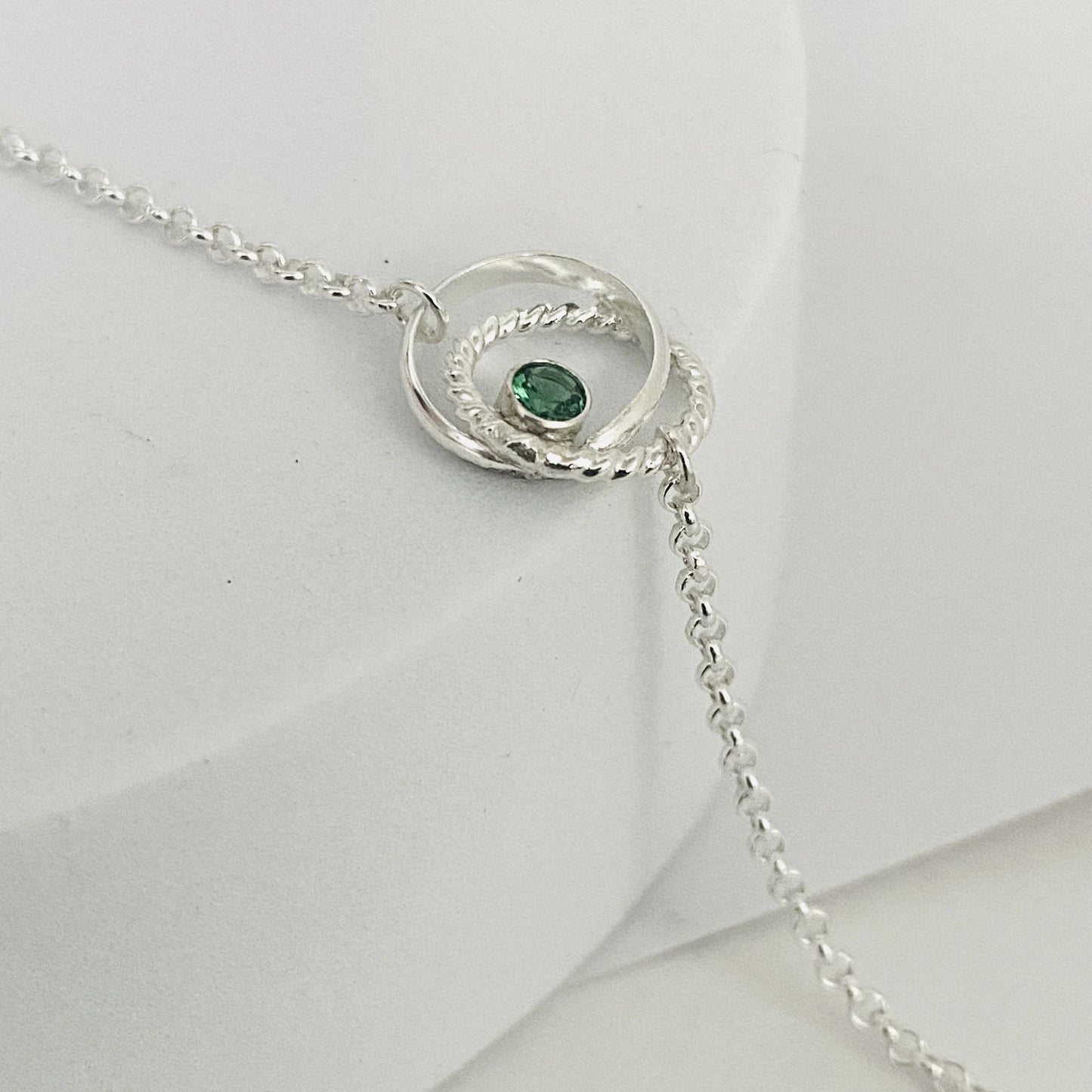 Luisana Jewelry bond bracelet featuring a silver chain and a green gemstone accent