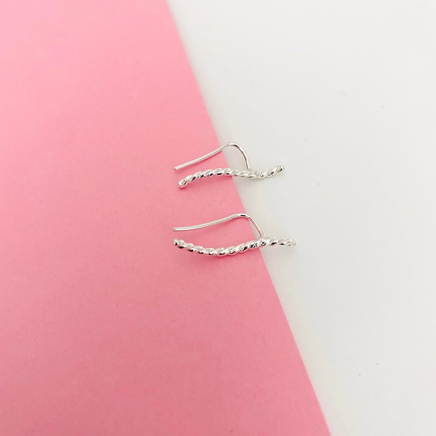 Luisana Jewelry Brisa earrings with a twisted design on a soft pink background
