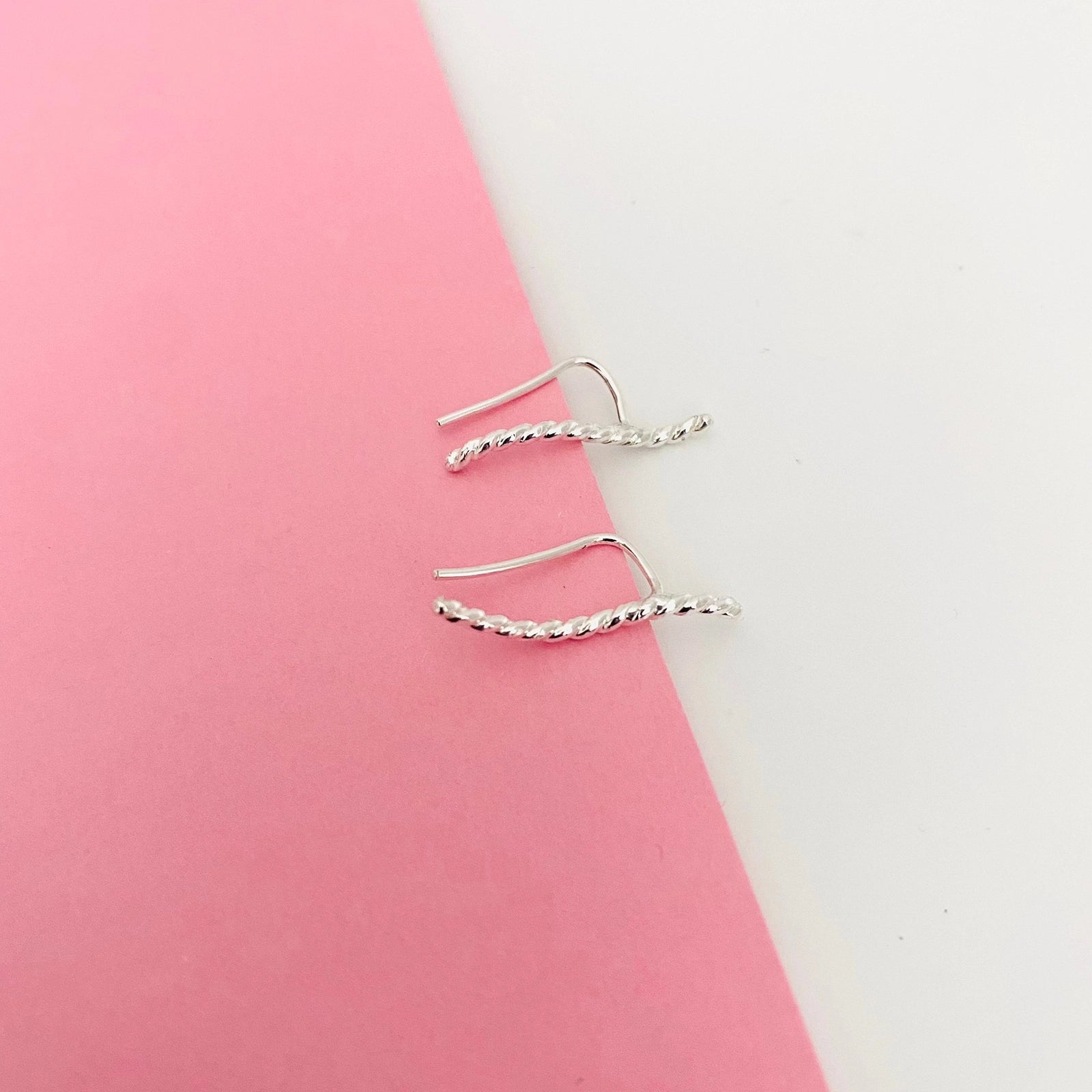Luisana Jewelry Brisa earrings with a twisted design on a soft pink background