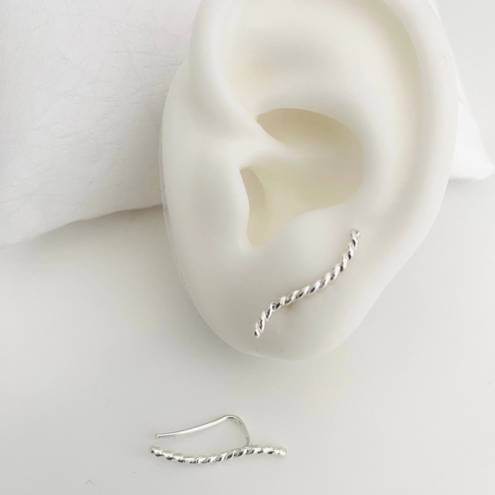 Luisana Jewelry Brisa earrings in twisted silver design displayed on a mannequin ear