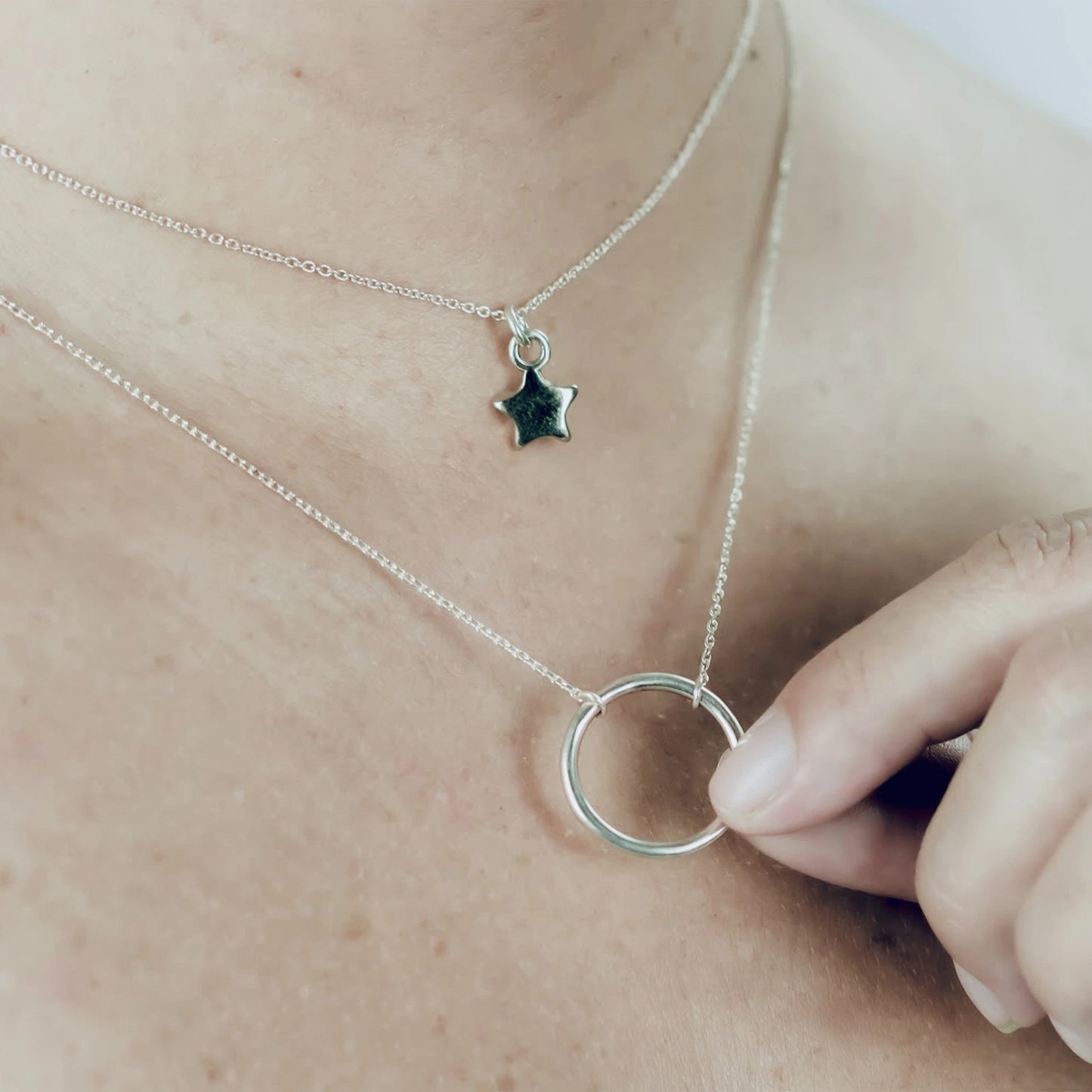Cloe Necklace layered with a star charm, featuring delicate silver chains for a trendy layered look