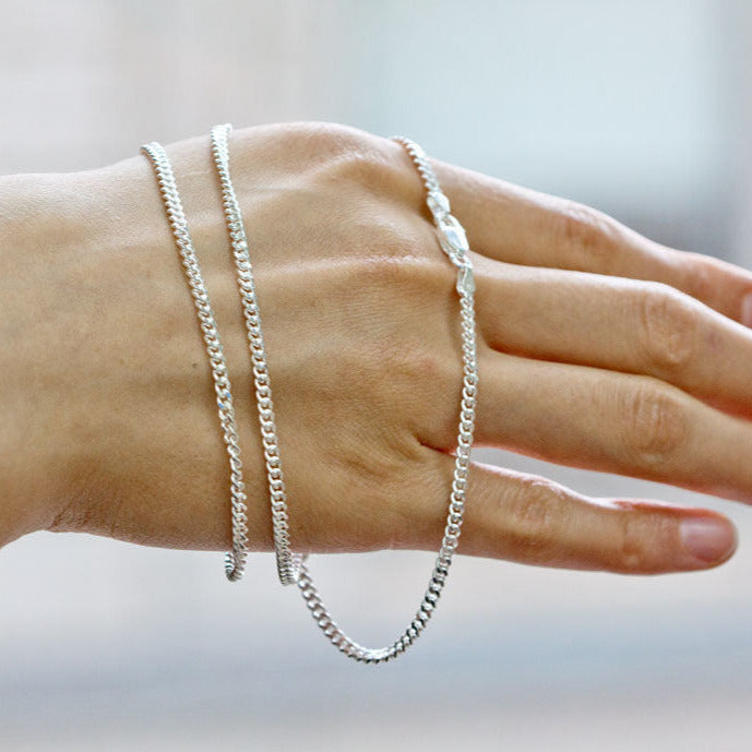 Luisana Jewelry Cuban Chain 1.4mm shown on a hand with a shiny silver finish for a stylish look