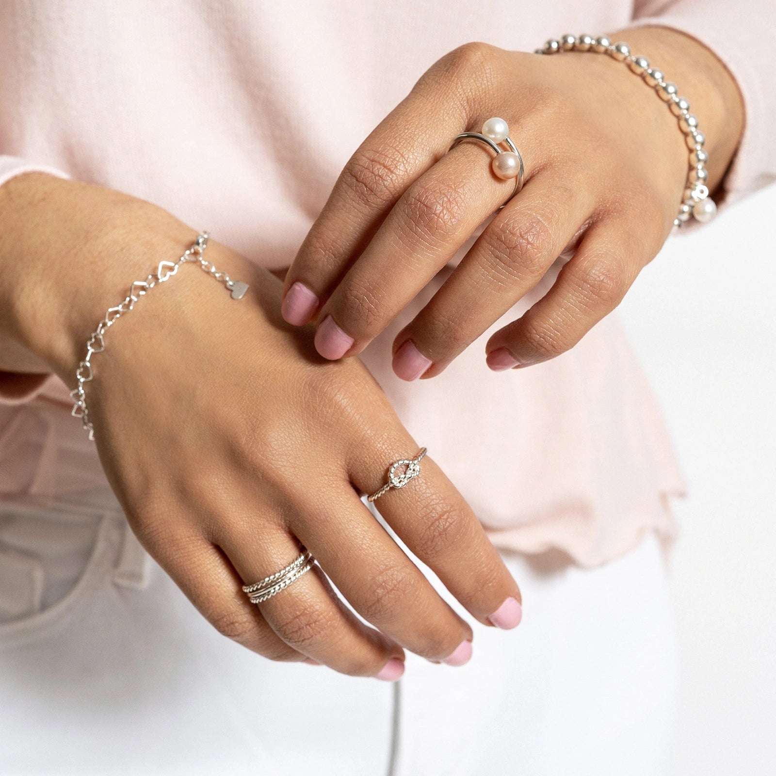Luisana Jewelry Florencia Ring showcased on a hand, styled with silver bracelets and pink nails