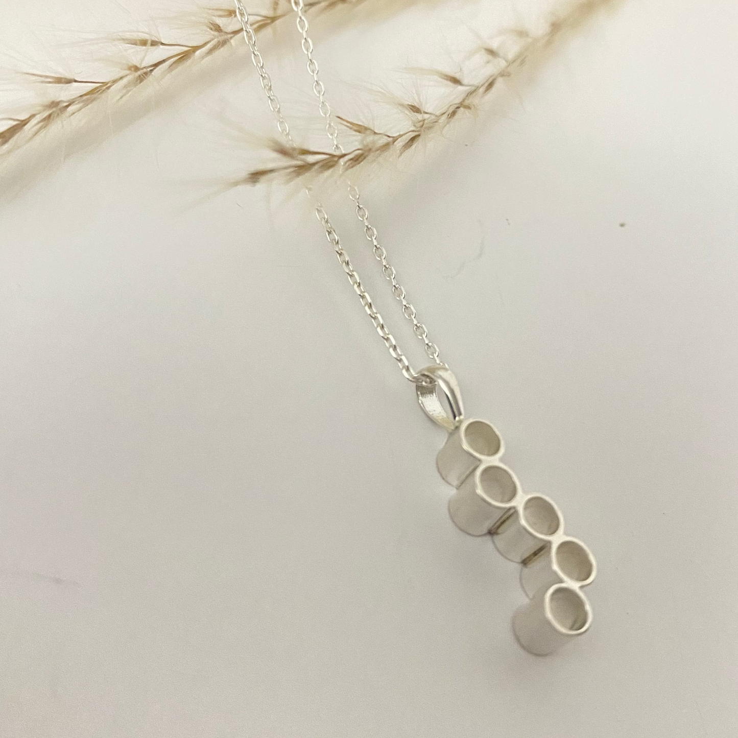 Silver Honeycomb Necklace with a modern design featuring interlocking honeycomb shapes