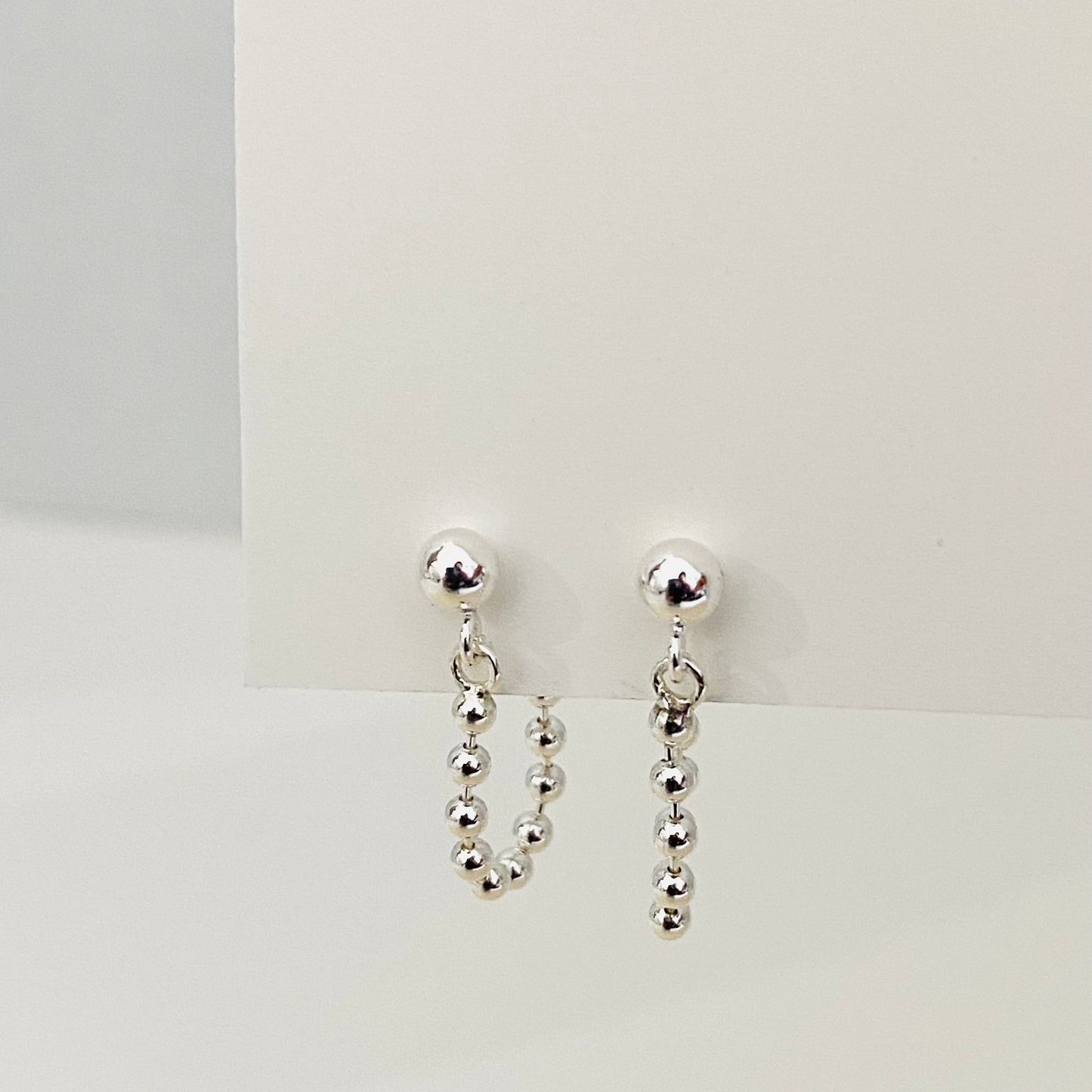 Luisana Jewelry Monique earrings featuring silver ball studs with dangling bead chains