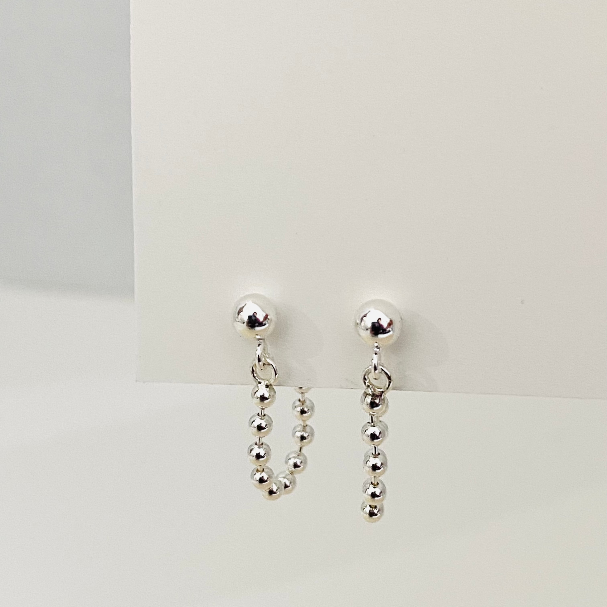 Luisana Jewelry Monique earrings featuring silver ball studs with dangling bead chains