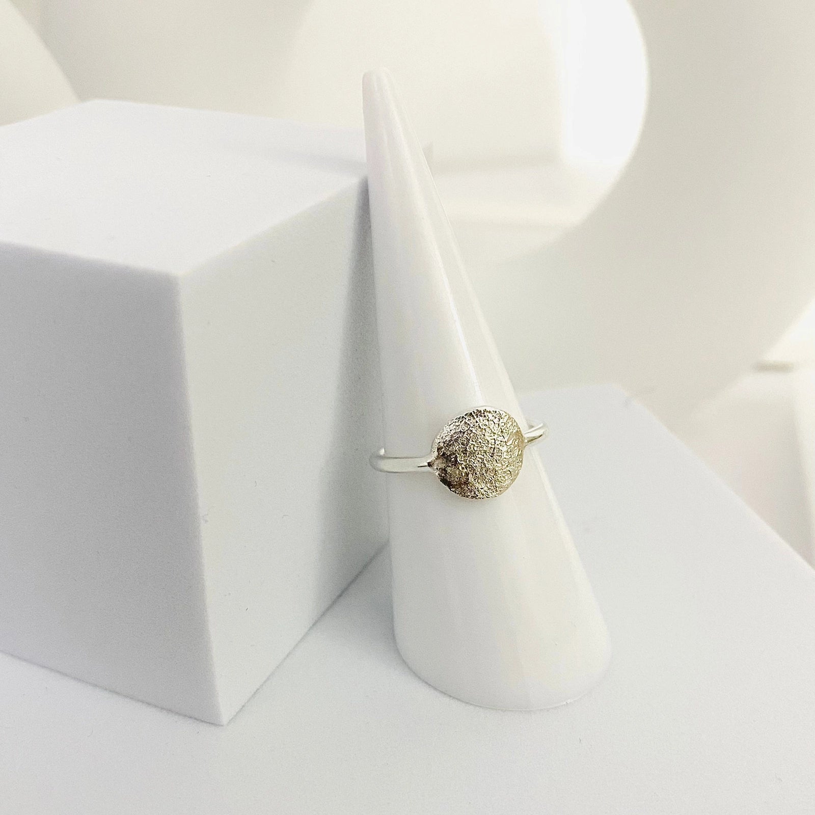 Luisana Jewelry Organic Love Ring with a textured design displayed on a cone-shaped ring holder