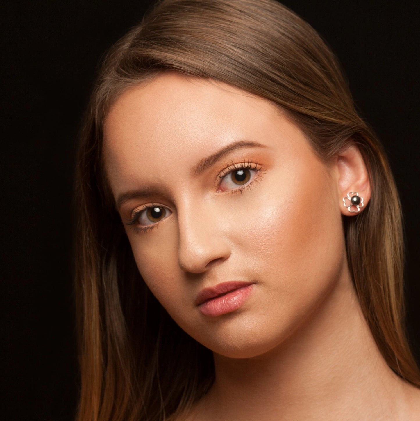 Luisana Jewelry Rose Earrings showcased on a model with long hair and a minimalistic background