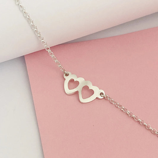 Luisana Jewelry two hearts bracelet in silver with a minimalist design featuring two heart charms